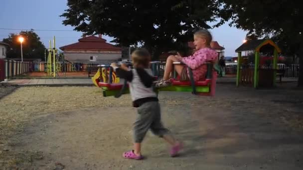 Little boy and girl having fun on playground - Felvétel, videó