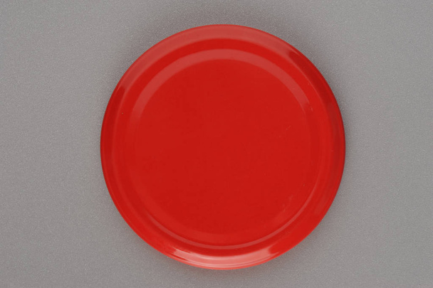 Screw cap for glass jars. For canning, canned food. Red cap on gray background - Fotografie, Obrázek