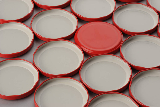 Tapas de tornillo para frascos de vidrio. Para enlatar, comida enlatada. Tapas rojas sobre fondo gris flip covers
 - Foto, imagen