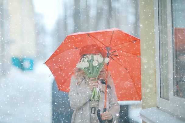 spring snowfall beautiful girl with flowers / concept of international women's day march, gift for girlfriend, happiness - Photo, Image