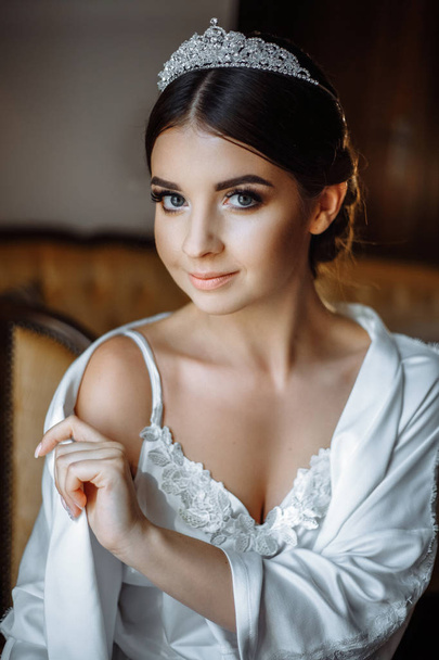 young beautiful bride posing in a robe by the window - Foto, immagini