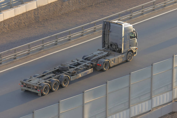Camion avec une longue remorque vide sans cargaison, conduite sur l'autoroute, vue de dessus
. - Photo, image