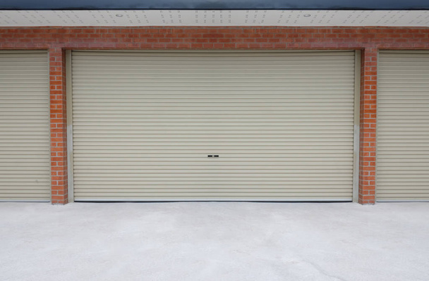 Рулонні сталеві двері або двері затвора і бетонна підлога зовні будівлі
 - Фото, зображення