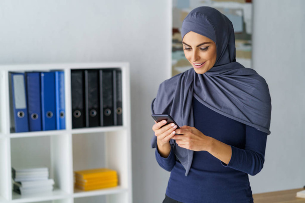 Arabic woman looking at phone - Foto, afbeelding