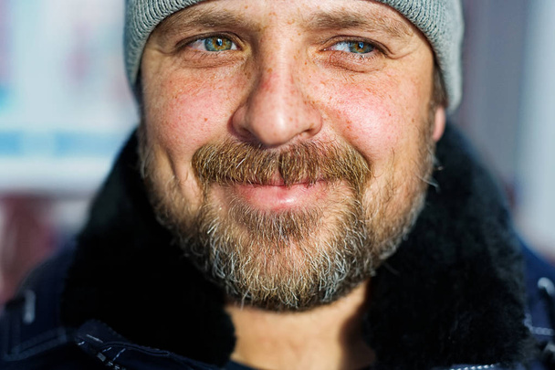 Een blanke man met een baard kijkt weg en glimlacht. Portret van een dromende boer close-up. - Foto, afbeelding