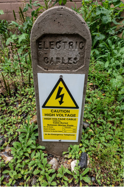 Cables eléctricos enterrados poste de identificación y advertencia
 - Foto, imagen