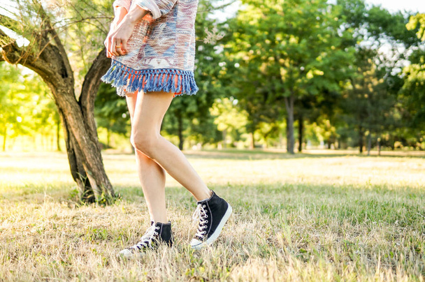 Stílusos lábak egy nőt walking füves területen - Fotó, kép