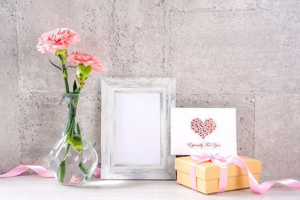 Close up, copy space, mock up, beautiful mothers day event concept handmade giftbox decoration photography, blooming fresh carnations with pink color ribbon isolated on gray wallpaper - Foto, immagini