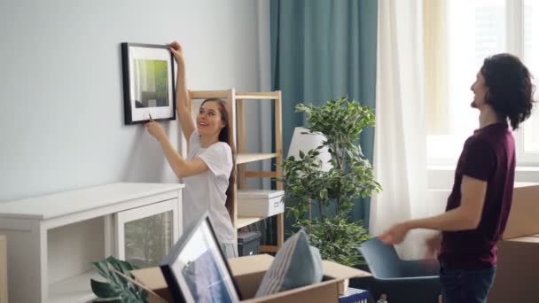 Man en vrouw opknoping foto kiezen plaats thuis tijdens de verhuizing - Video