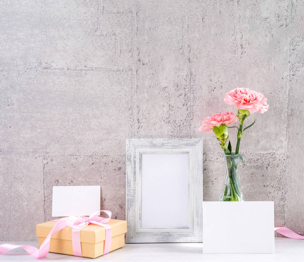 Close up, copy space, mock up, beautiful mothers day event concept handmade giftbox decoration photography, blooming fresh carnations with pink color ribbon isolated on gray wallpaper - Fotografie, Obrázek