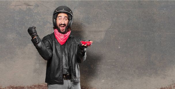 motorbike rider holding a red car model - Fotó, kép