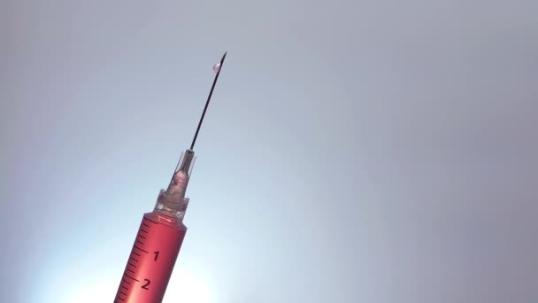 Skośna strzykawka kapiąca czerwona ciecz powoli - Materiał filmowy, wideo
