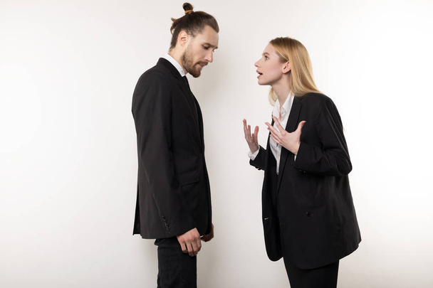 The female boss in black suit scolds her bearded manager for not being attentive - Foto, immagini