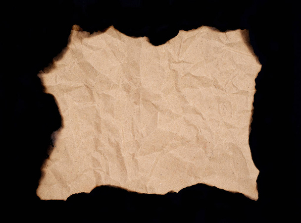 hoja de papel quemado aislada sobre fondo negro - Foto, imagen