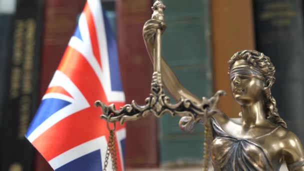 Standbeeld van Lady Justice met boekenplank met boek en Britse vlag achtergrond - Video
