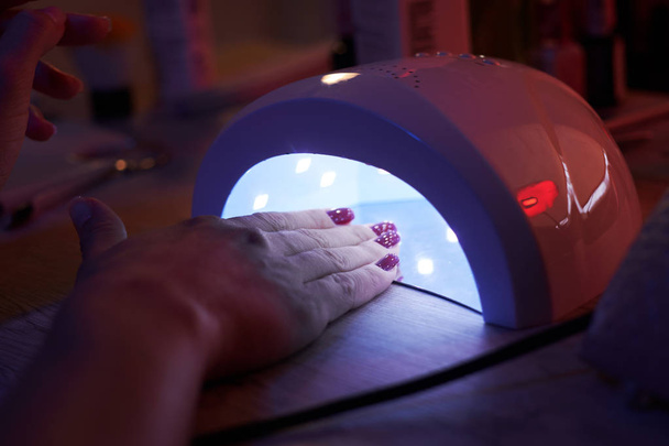 Led UV lamp is drying woomans nails. - Photo, Image