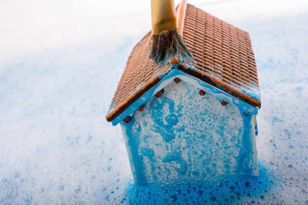 Model huis en schilderen penseel in schuimend water - Foto, afbeelding