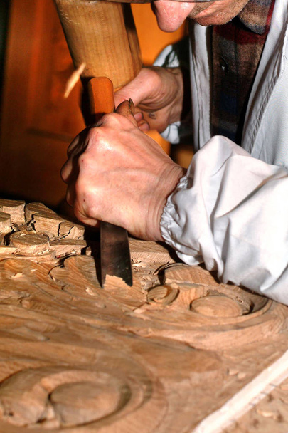 Craftsman carves wood with chisel. - Photo, Image