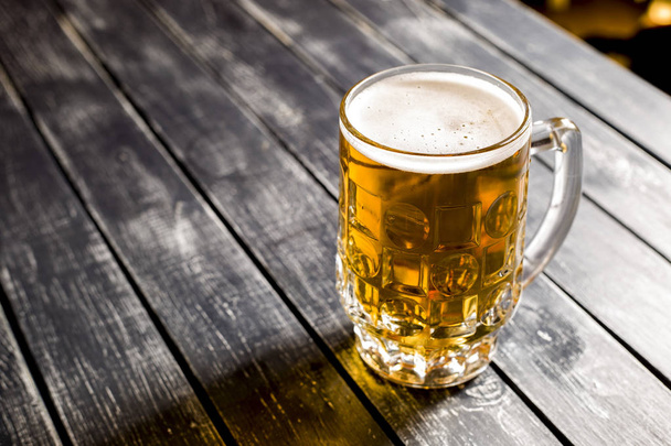 Egy bögre friss könnyű sör egy bárban fából készült asztal. Felülnézet. Lemezterület másolása.  - Fotó, kép