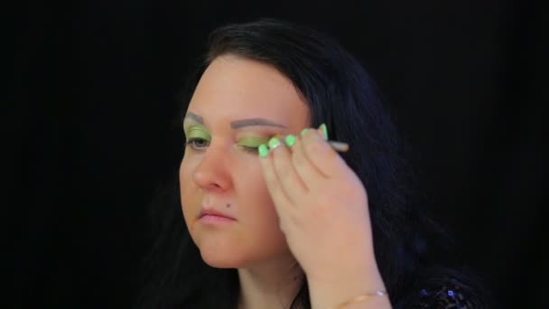 Brunette vrouw maakt oog make-up met groene schaduwen - Video