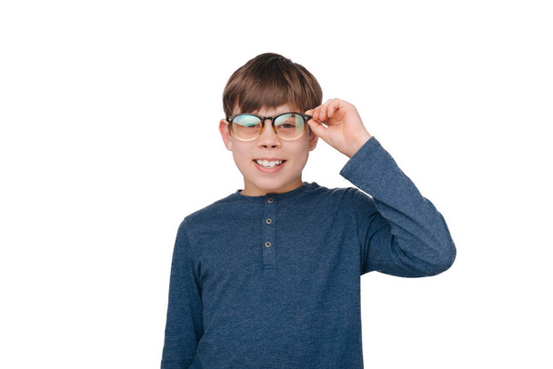 Piccolo ragazzo nerd guardando la fotocamera e toccando i suoi occhiali
  - Foto, immagini