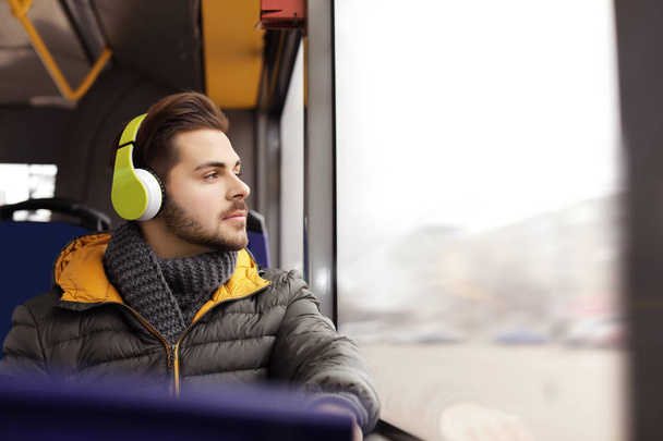 Young man listening to music with headphones in public transport - Photo, Image