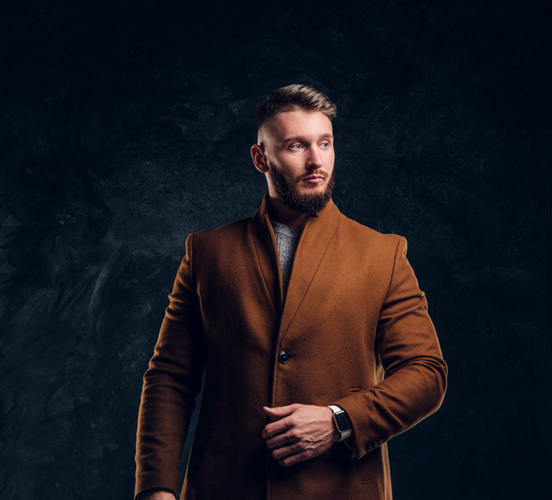 Retrato de um homem elegante vestindo o casaco demi-temporada. Beleza masculina, moda sazonal. Foto do estúdio contra um fundo de parede escura
 - Foto, Imagem