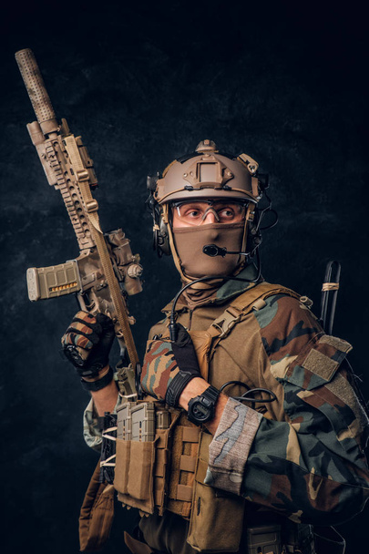 Ελίτ μονάδα ειδικών δυνάμεων στρατιώτη στο καμουφλάζ ομοιόμορφη ποζάρει με επίθεση τουφέκι. - Φωτογραφία, εικόνα