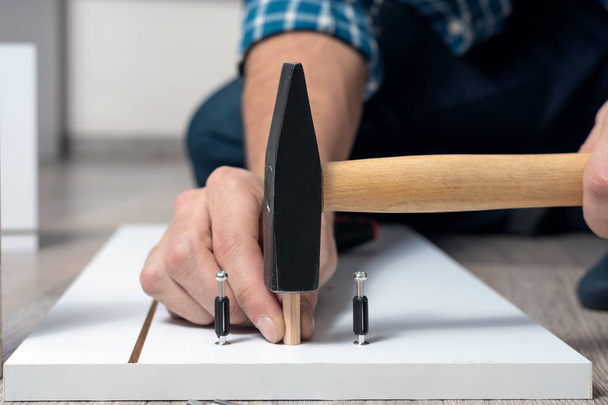 close-up of male hands assembling furniture with hammer - Foto, Imagem