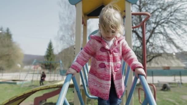 Zabawna cute girl gra. Radosne kobiece dziecko bawią się na placu zabaw - Materiał filmowy, wideo