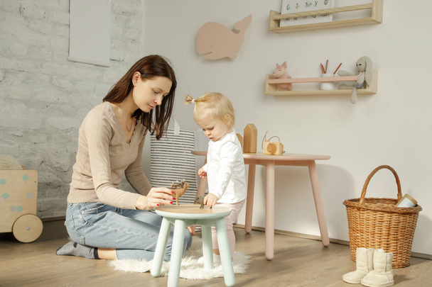 Adorable baby girl playing with her mum in the nursery room - Photo, Image