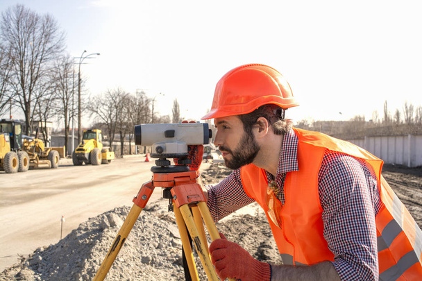 ingegnere geometra maschio con un dispositivo che lavora in un cantiere in un casco
 - Foto, immagini