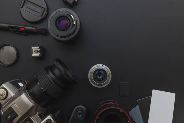 Fotós munkahely DSLR fényképezőgép rendszer, kamera tisztító készlet, lencse és a kamera tartozék sötét fekete asztal háttér - Fotó, kép