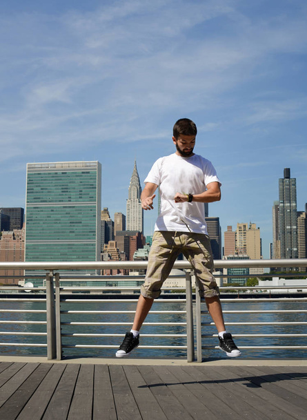 Mann springt und schaut auf seine Uhr in New York - Foto, Bild
