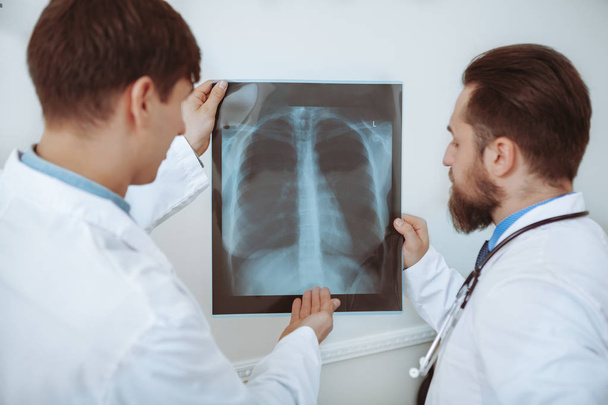 Двоє чоловіків-лікарів обговорюють рентгенівські сканування в лікарні
 - Фото, зображення