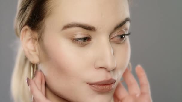 Modelo de belleza tocando la piel de la cara en cámara lenta. Primer plano de cara de mujer joven - Imágenes, Vídeo
