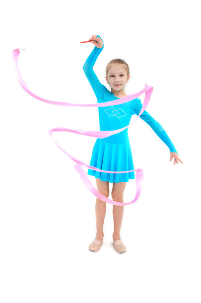 Young girl gymnast exercising with pink ribbon on white - Photo, Image