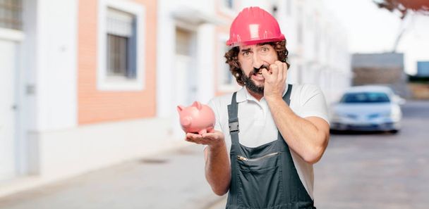 young man worker with a piggy bank - Fotó, kép