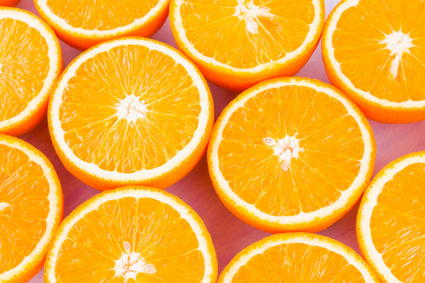 Background of oranges fruits. Many halves of fresh oranges, top view. Citrus for making juice. A lot of sliced oranges on white background. Concept - Photo, image