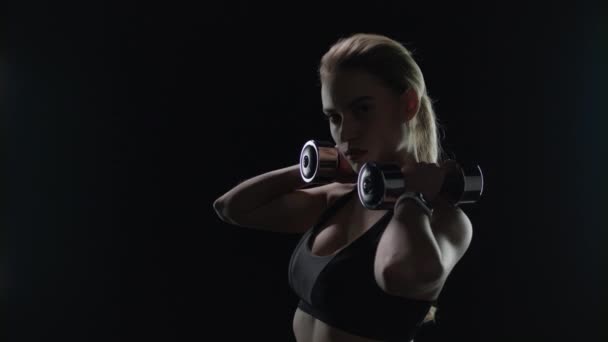 Chica en forma posando con pesas en los hombros en el estudio. Silueta de mujer deportiva - Imágenes, Vídeo