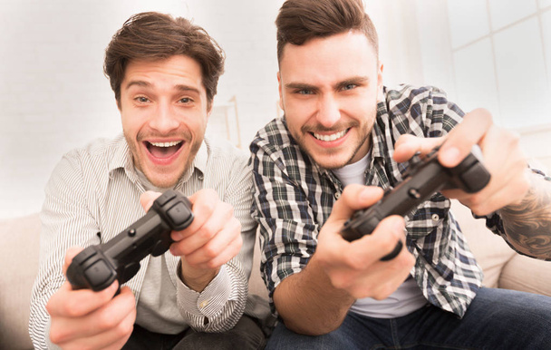Jugadores. Chicos felices jugando videojuegos en casa
 - Foto, imagen