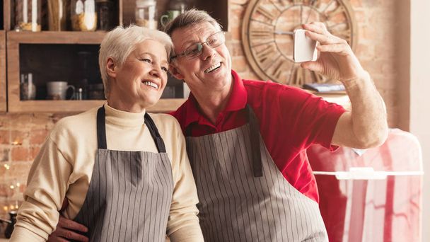 Senioren-Paar macht Selfie mit Smartphone in Küche - Foto, Bild