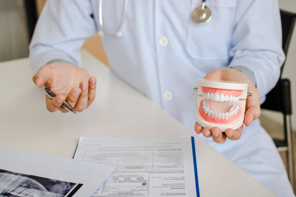 Стоматологи обсуждают стоматологические проблемы на рентгеновском снимке отчета
 - Фото, изображение