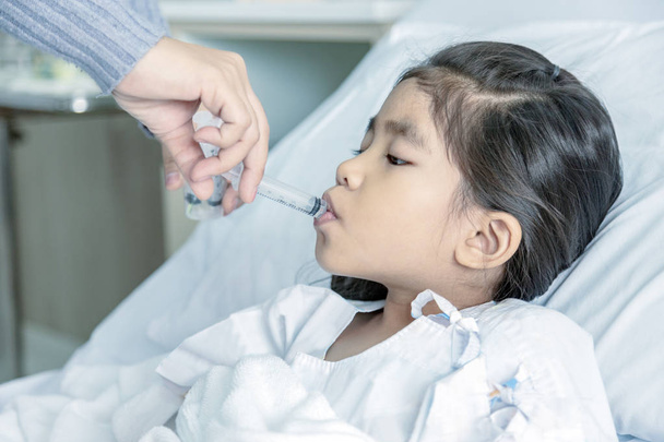 Doctor heal kid water medicine in hosital clinic room. - Фото, зображення