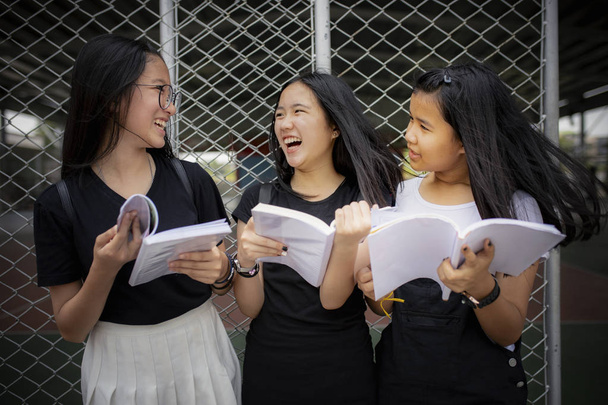 Asya genç tutan okul kitap ve gülmek ile mutluluk e - Fotoğraf, Görsel