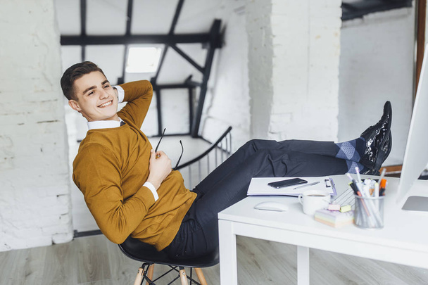 Young businessman resting at office during break - Foto, afbeelding