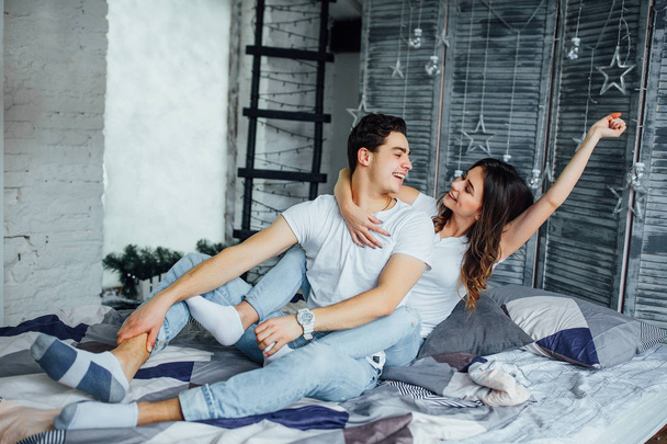 Young couple hugging at home and smiling together - Фото, зображення