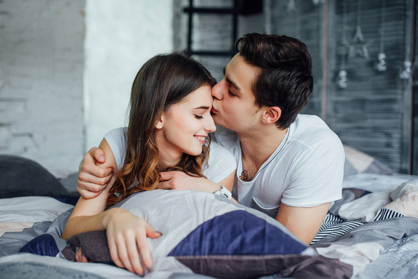 Young attractive couple having romantic time in bed at home - Fotografie, Obrázek