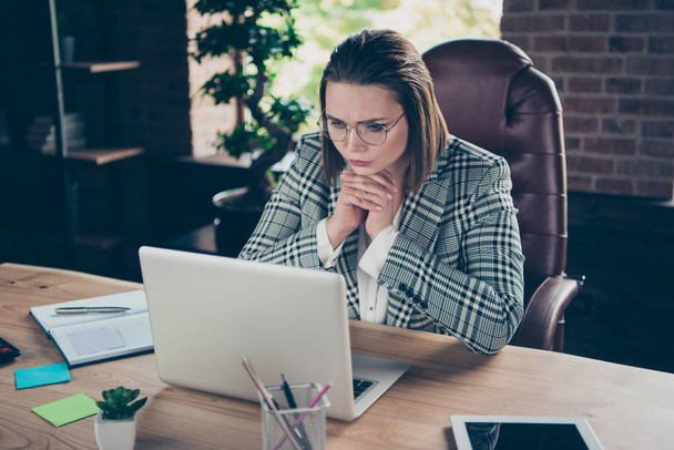 Close up photo ponder pensive she her business lady look attentively counting payment reader concentrated fingers crossed notebook table sit office chair wearing specs formalwear checkered plaid suit - Foto, imagen