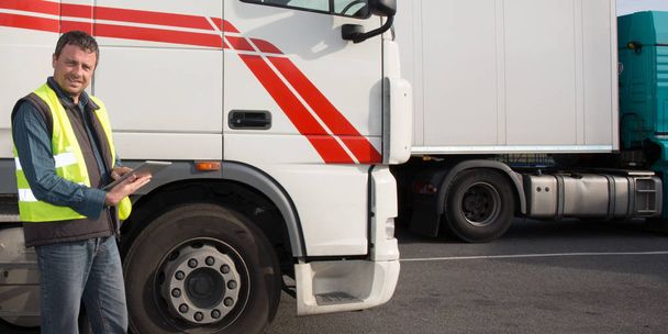 Водитель грузовых автомобилей перед кабиной большого современного грузовика
 - Фото, изображение